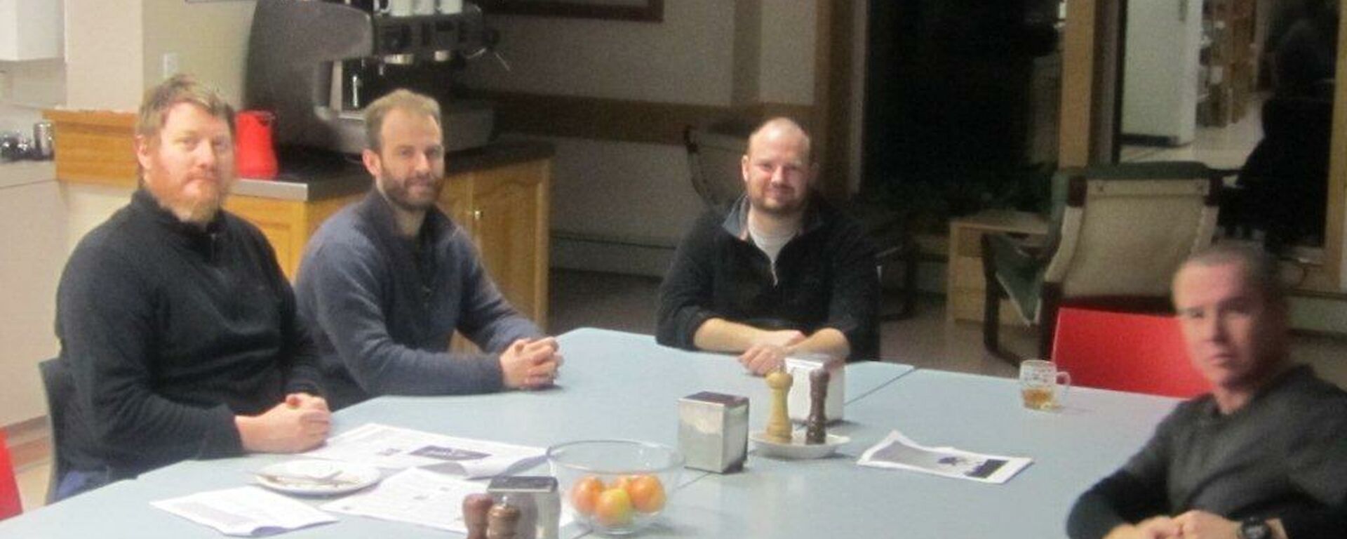 Expeditioners sitting around the mess table after dinner and enjoying a chat