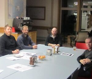 Expeditioners sitting around the mess table after dinner and enjoying a chat