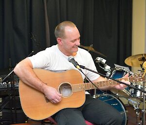 Rocket strumming his guitar whilst singing