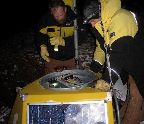 Two tradesmen repairing the Mt Parsons radio repeater late in the evening.