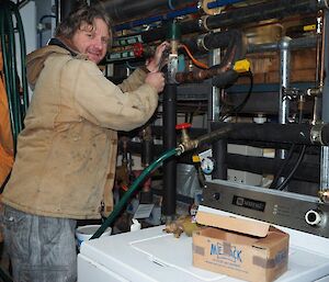 Plumber Craig repairing a flow valve on the hydronic hot water heating system for the living quarters