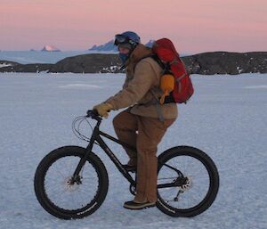 Dactor James cycling across the sea ice wearing heavy duty Carhatt overalls and jacket — setting the new fashion trend in biking apparel?