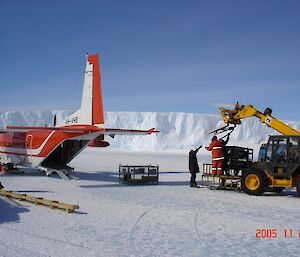 CASA on ground with expeditioner and heavy plant nearby with cargo