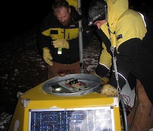 Garry and Two expeditioners repairing a radio repeater on Mt Parsons during the night