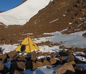 The overflow accommodation. A bright yellow polar pyramid stands alone at the base of the snow and scree slope leading to the East peak of Mt Hordern