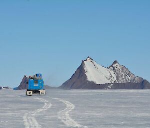 A Hägglunds making tracks in freshly laid snow as it drives toward the rocky outcrop of Mt Hordern