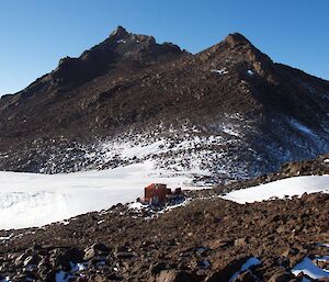 Henderson hut tucked away and out of the wind with Mt Henderson towering in the background