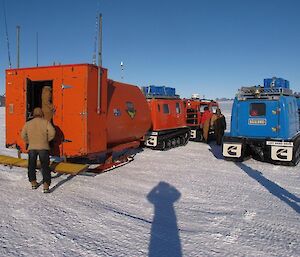 The self contained RMIT van being towed behind a Hägglunds