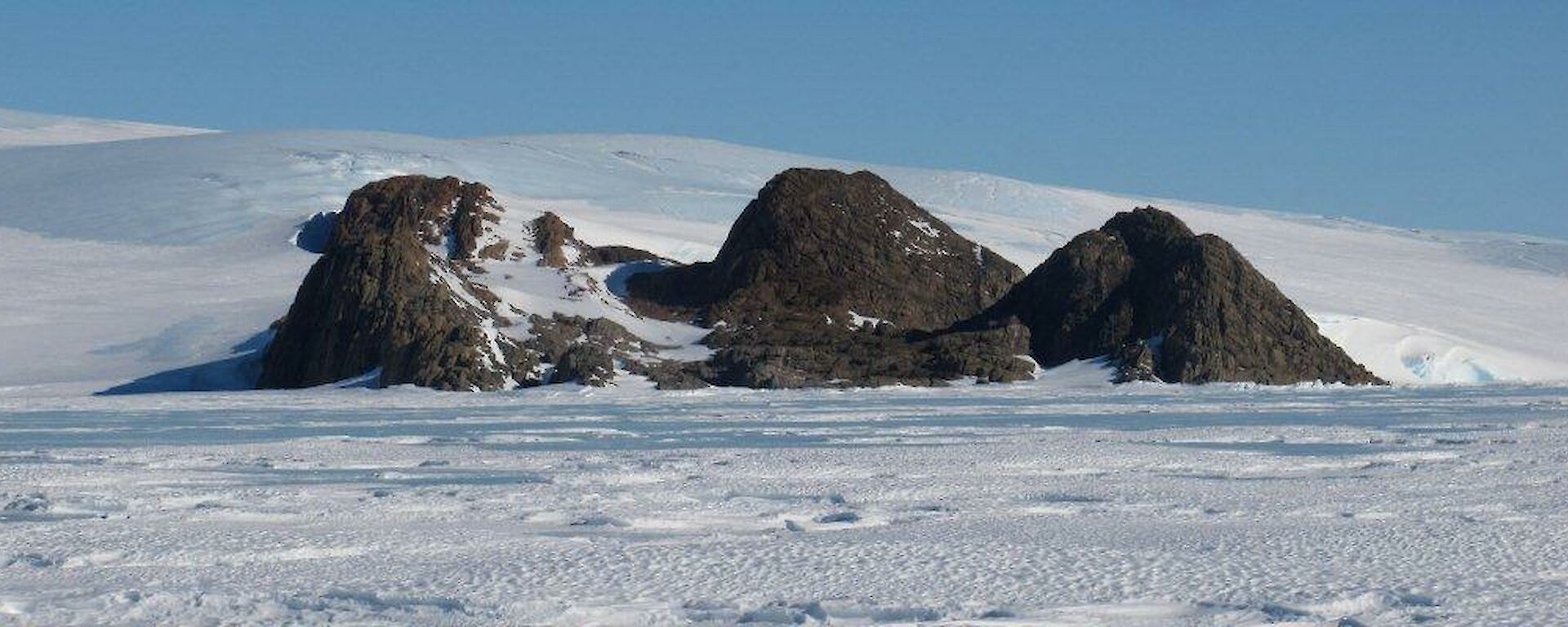 Looking across the frozen ice toward the rocky outcrop of Tilly Nunatuk
