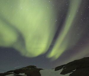 An aurora with a shooting star darting across the sky