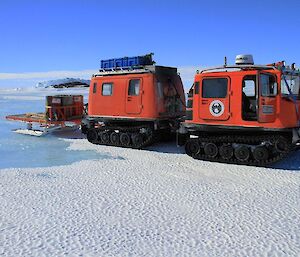 The orange Hägglunds parked on the sea ice as it makes its way to Taylor Glacier