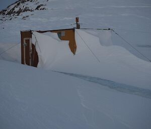 There is a door in there somewhere — the front entrance of the Colbeck Hut is covered in snow which had accumulated since last season