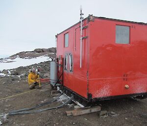 The finished product — the Colbeck Hut painted in Aurora Australis orange and sitting at its new location