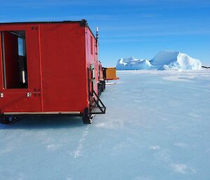 On the road again. The hut is hooked up to a Hägglunds and driving across the sea ice bound for Mawson Station