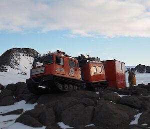 A Hägglunds pulling the hut up and over rocks to it’s new resting place