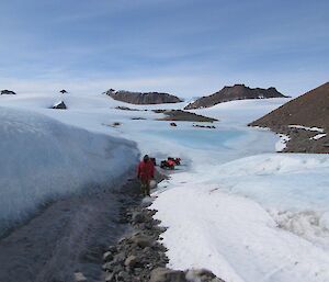 An expeditioner walking along side a wind scour