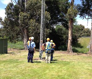The communications team at the base of a mast receiving instruction