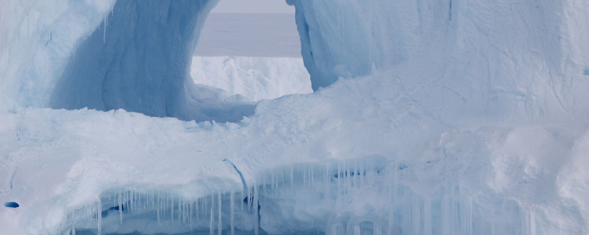 A hole in a large iceberg looks like a cave entrance