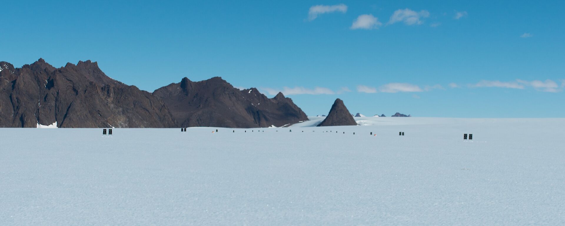 A panorama image of the ice covered Rumdoodle plateau showing newly placed flags