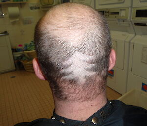 A Christmas tree shaved on an expeditioners head during a haircut