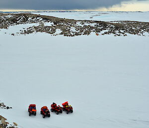 Four quad bikes parked on the snow