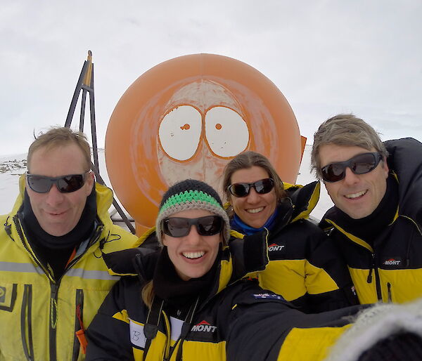 Four expeditioners posing for a photograph outside a field hut