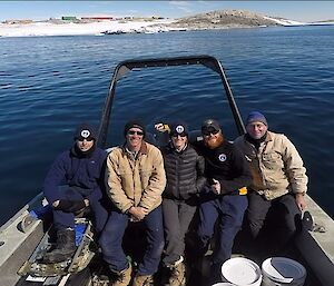 Five expedtioners sitting in the rear of a boat
