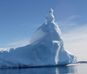 A photo of an iceberg floating in water on a clear day