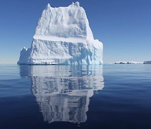 An iceberg with its image refelcting on the water