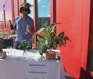 An expeditioners serving a drink behind a table