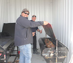 Two expeditioners cooking the spit roast