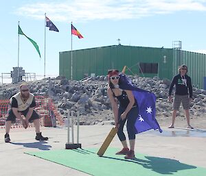 A female expeditioner wearing an Australian Flag playing cricket