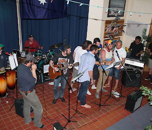 A group of expeditioners signing and playing music