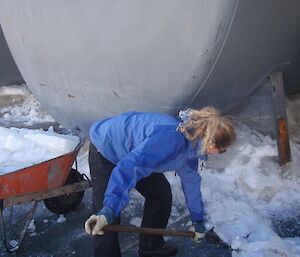 A female expeditioner digging snow