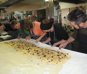 Six expeditioners wrapping the strudel ingredients inside the pastry