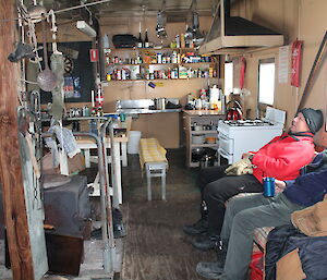 Two expeditioners sitting on a couch in front of a fire