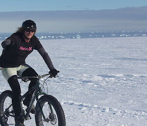 An expeditioner on a bike on the snow