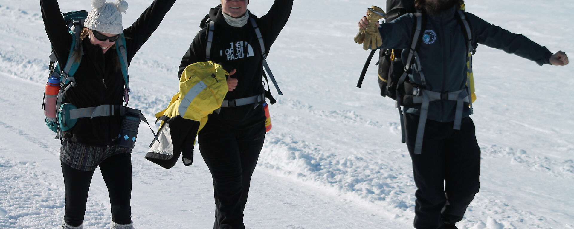 Three expeditioners walking on snow