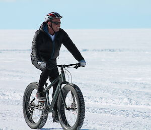 An expeditioner on a bike riding on the snow