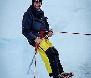 An expeditioner about to absail down a ice cliff