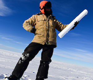 An expeditioner holding an ice core