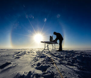 A scientist in the field with a table and computer