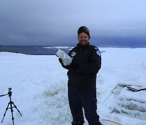 Expeditioner hold up a block of ice