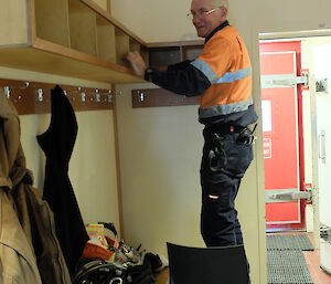 Expeditioner sweeps top of shelving