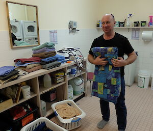 Expeditioner Grant is folding sheets in the laundry