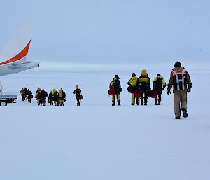 Departing expeditioners board a plane