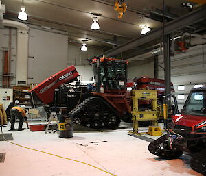 Station mechanical workshop with large tracked vehicles inside a giant shed
