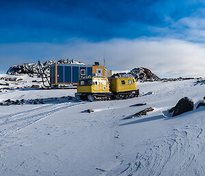 The yellow Hägglunds vehicle parked in front of Brownings field hut