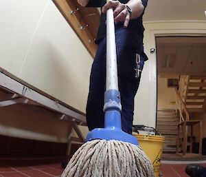 Expeditioner cleans floor with a mop