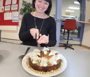 Female doctor with bob haircut, cuts her birthday cake